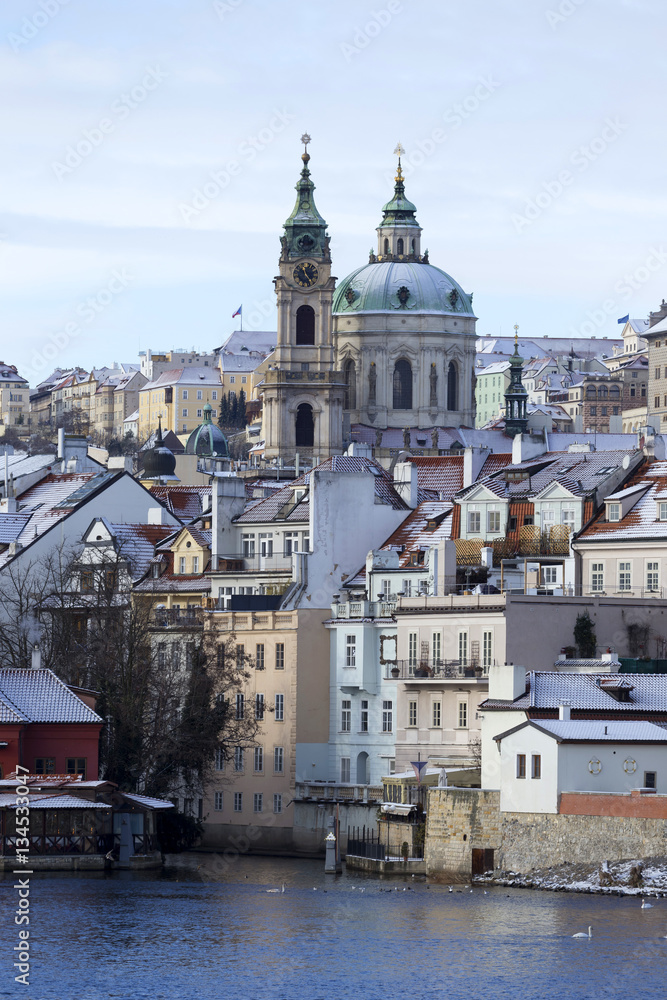 Snowy freeze Prague Lesser Town with St. Nicholas' above River Vltava, Czech republic 