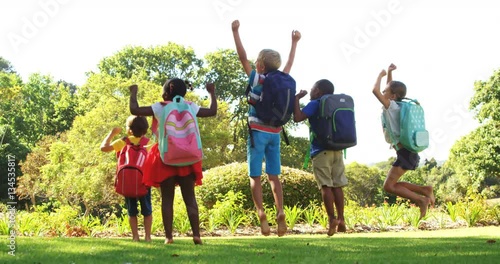 Group of kids jumping together in park on a sunny day 4k 