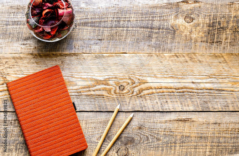 composition of orange notebook with flower sachets on wooden tab composition of orange notebook with flower sachets on wooden tab