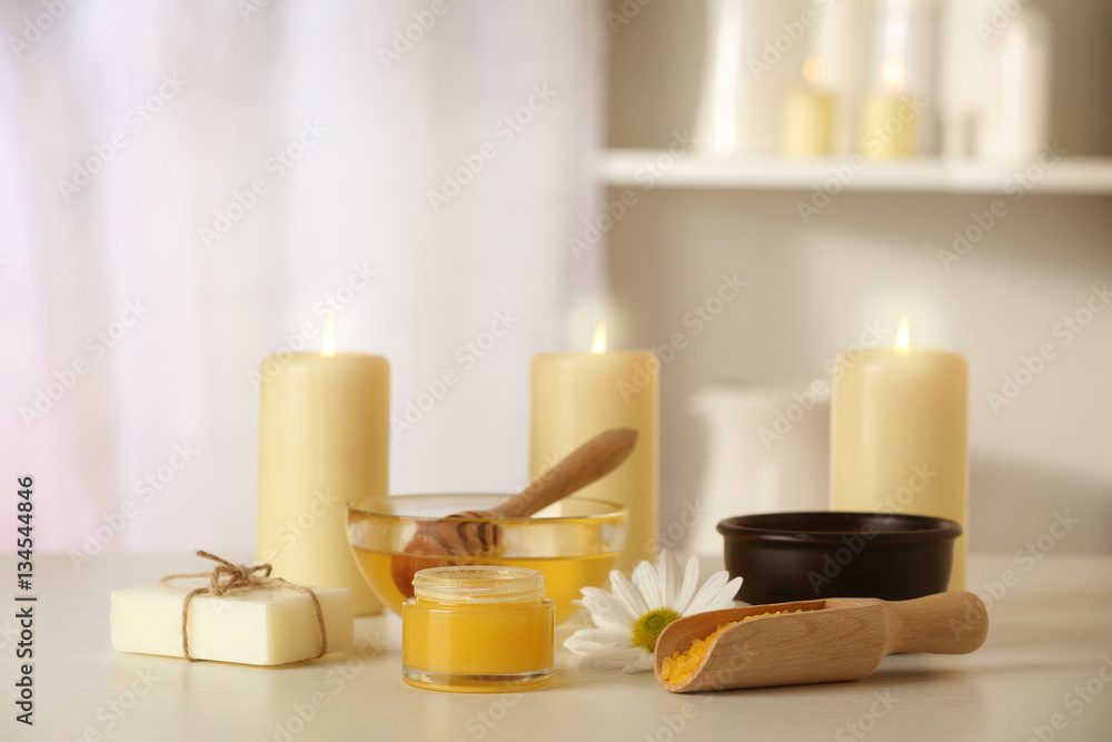 Spa set with honey treatments and candles on white table