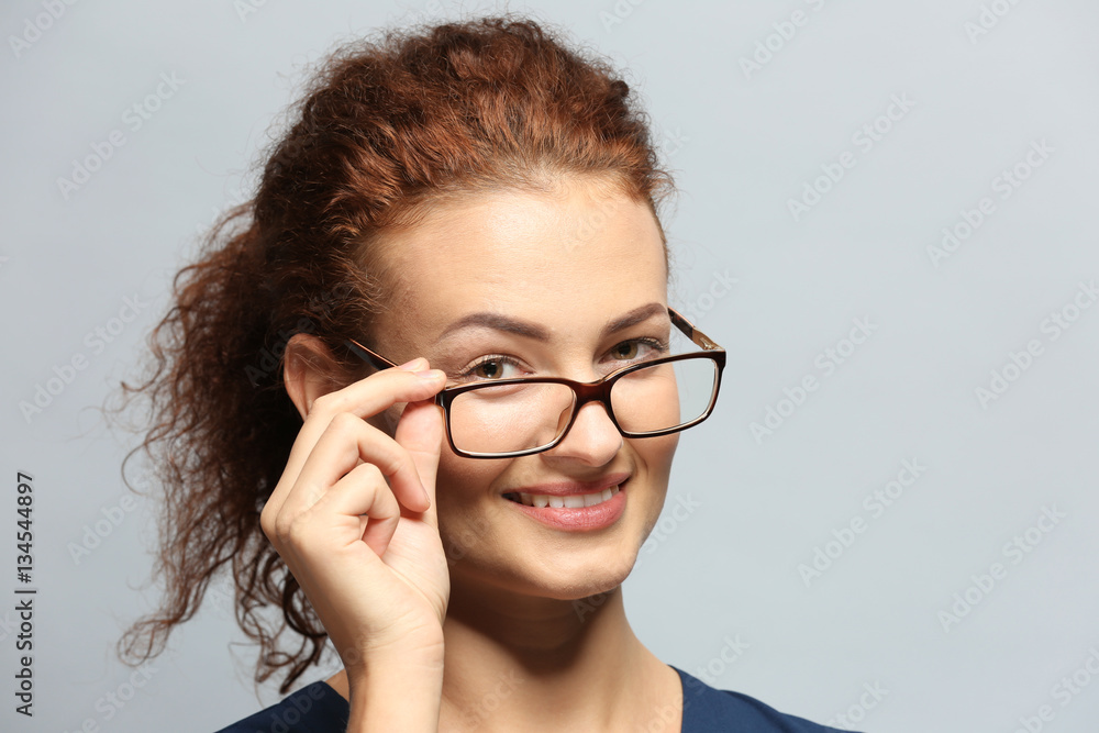 Young woman with spectacles on grey background Young woman with spectacles on grey background