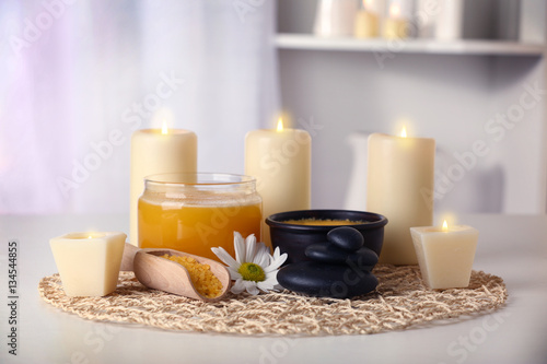 Spa set with honey treatments and candles on wicker mat