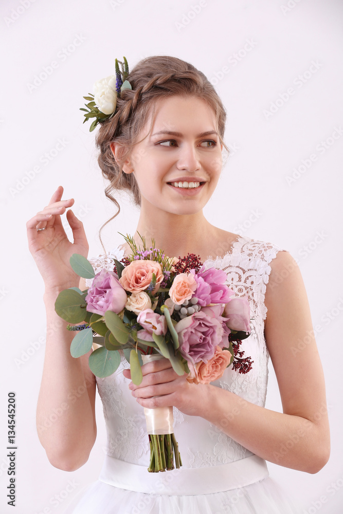 Young beautiful bride holding wedding bouquet on white background Young beautiful bride holding wedding bouquet on white background