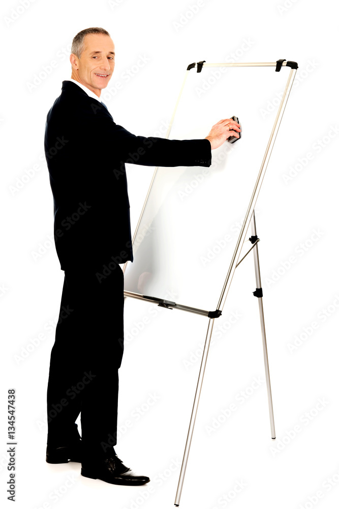 Male executive cleaning a flip chart Male executive cleaning a flip chart