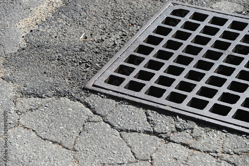 rustic square manhole drain cover in the street