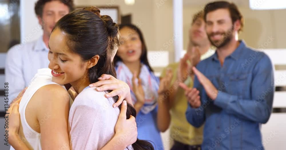 Two womens hugging each other while colleagues clapping in background at office 4k Two womens hugging each other while colleagues clapping in background at office 4k