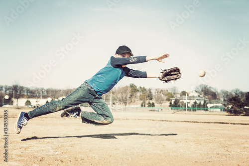 Boy jumpingto catch a baseball