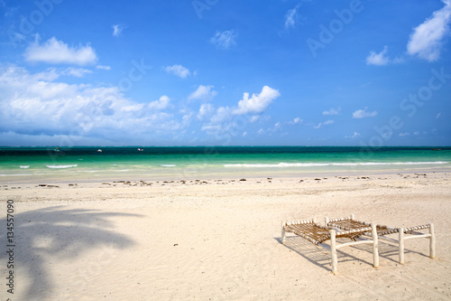 White sand beach with wooden deck chairs in Zanzibar © Oleksandr Dibrova