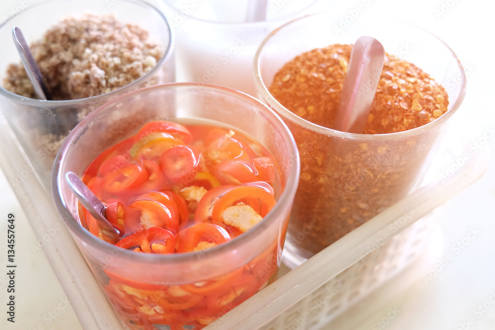 Seasoning set for noodle Thai food style, sugar, vinegar, chopped peanuts and cayenne pepper,selective focus , light effect. Seasoning set for noodle Thai food style, sugar, vinegar, chopped peanuts and cayenne pepper,selective focus , light effect.