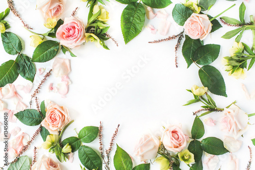 Frame of pink roses, branches, leaves and petals isolated on white background. Flat lay, top view