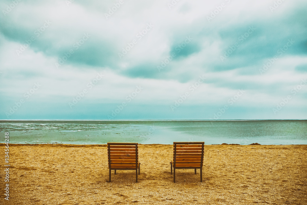lonely deckchairs on empty winter beach, loneliness symbol, abstraction