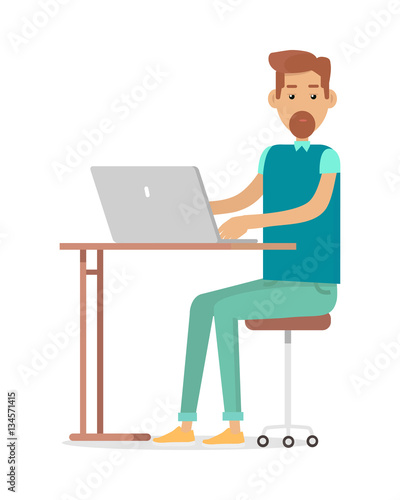Man with Beard Sitting at Desk Working on Notebook