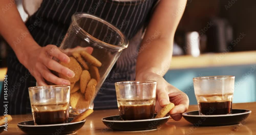 Mid section of waitress placing cookies next to tea cup 4k Mid section of waitress placing cookies next to tea cup 4k