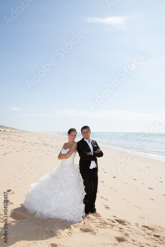 wedding couple back to back on the sand beach with ocean