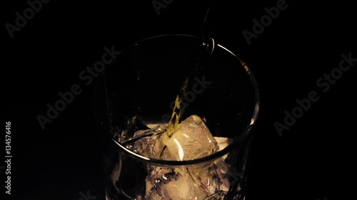 Slow mo whiskey with ice in a glass