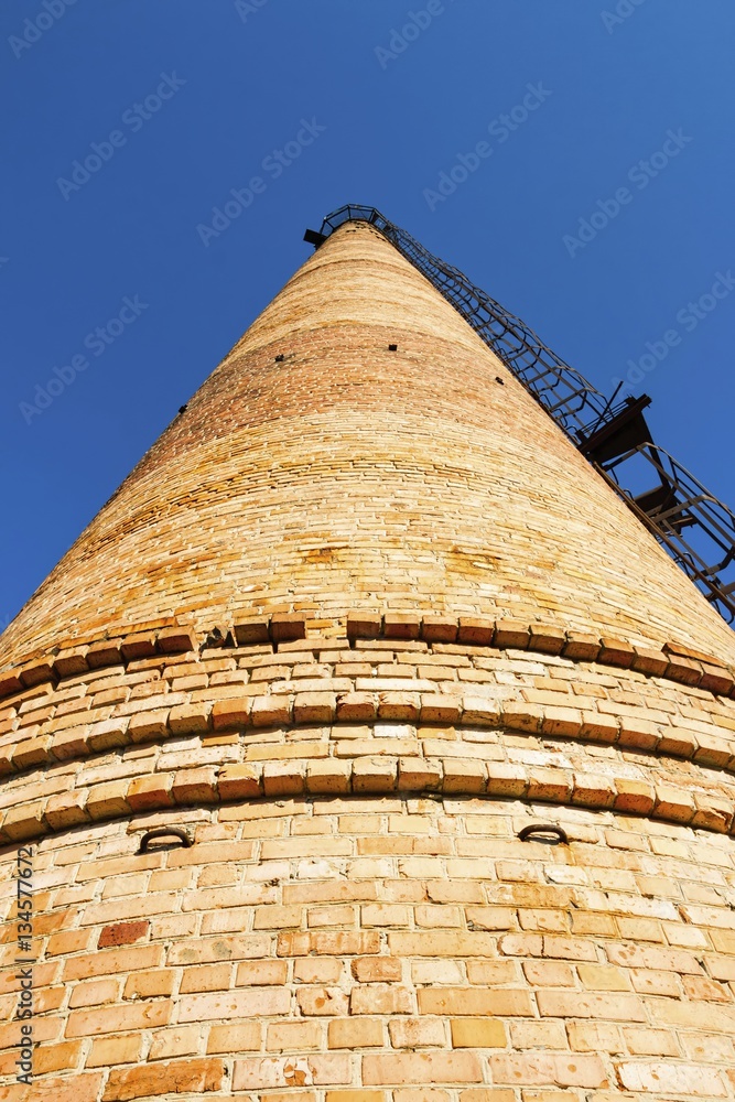 Factory chimney. Old crumbling pipe made of bricks. Steadicam shot.
