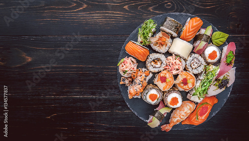Obraz na płótnie sushi on a black wooden surface w salonie