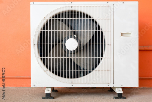 Принти на полотні Condensing unit of air conditioner at a red-orange painted wall