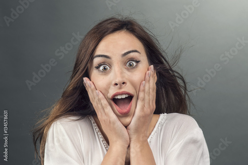 Portrait of young woman with shocked facial expression..