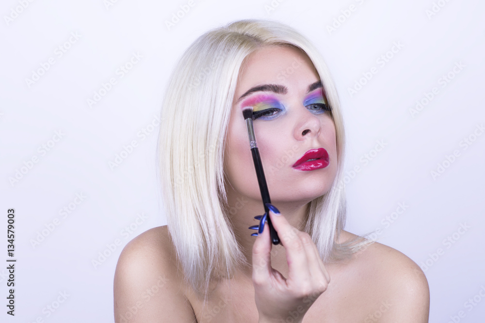 Portrait of a beautiful woman applying eye shadow Portrait of a beautiful woman applying eye shadow