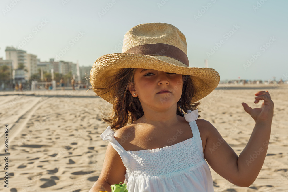 Close up portrait girl wearing wicker hat in summer. Beach backg