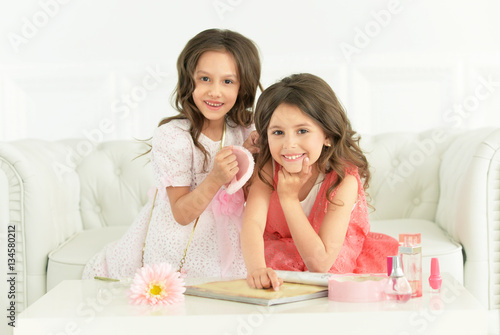 two little girls reading magazine
