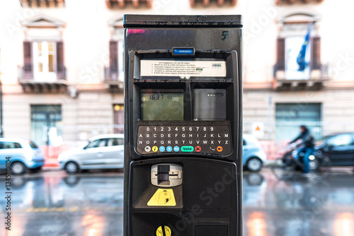 Parcometro in una strada di città, funzionante con denaro contante e con carte di credito.