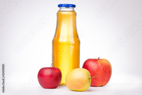 Three apples and a bottle of apple juice on white background