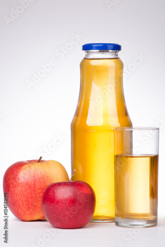 Two apples and a bottle of apple juice on white background