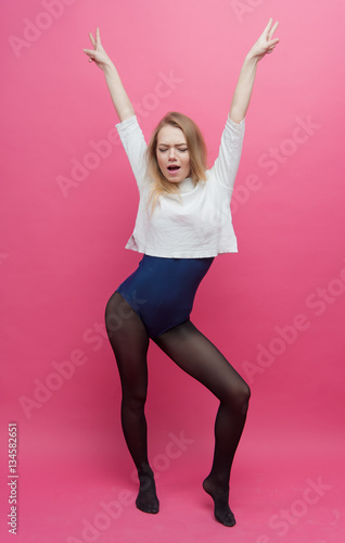 girl in black tights dancing on a pink background
