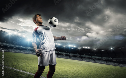 Photography Football player withstand a ball with his chest in the stadium