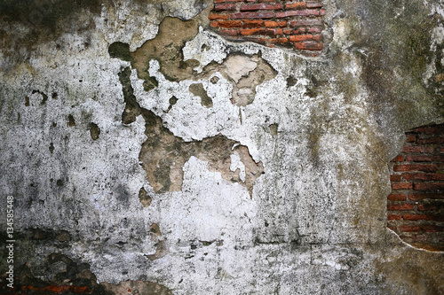 Cracked plaster of old brick wall
