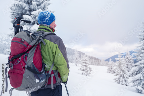 Man with backpack in snow covered forest