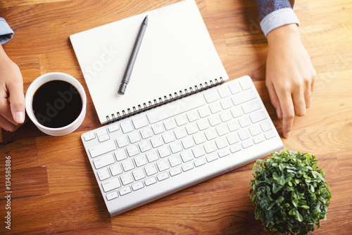 women writing and key board coffee on wooden table