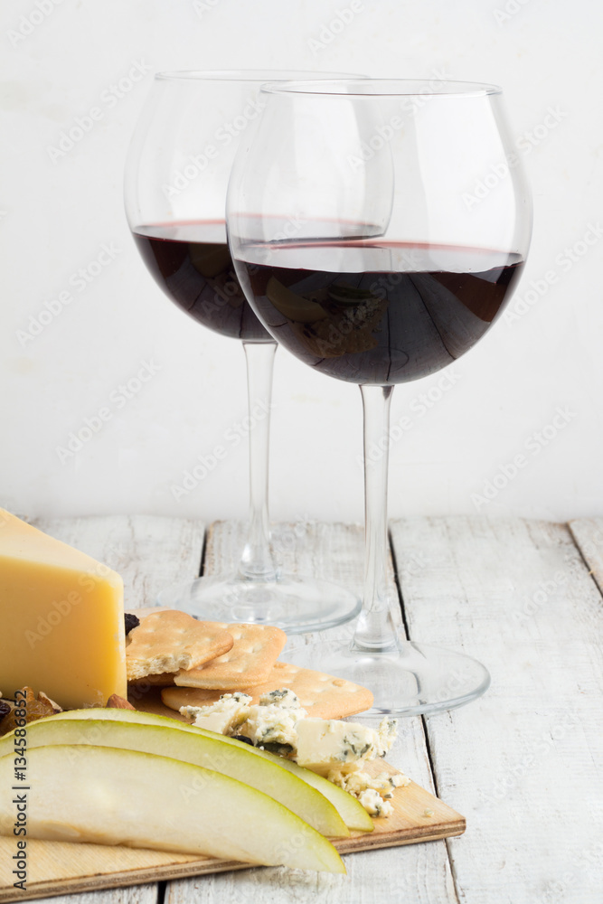 glasses with red wine and cheese with fruit