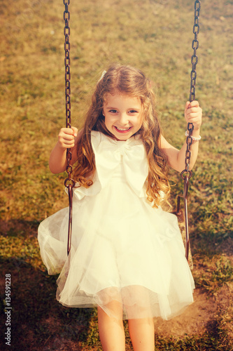 Cute Girl Swinging In Park