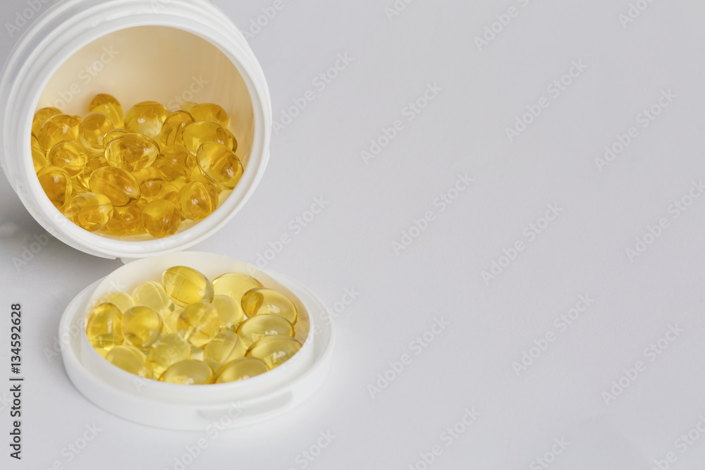 Soft gels pills with Omega-3 oil of pill bottle close-up on a white background Soft gels pills with Omega-3 oil of pill bottle close-up on a white background