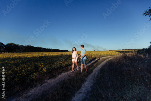 Charming expecting couple walks across the field