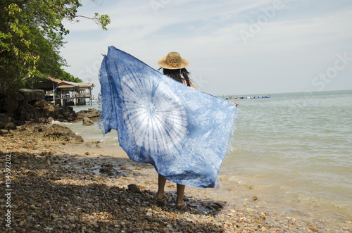 Asian thai woman posing with keep rock and seashell on hand at stone beach
