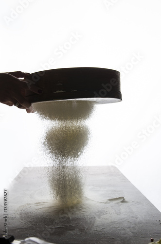 Woman hands holding Sieve flour with beautiful light , close up
