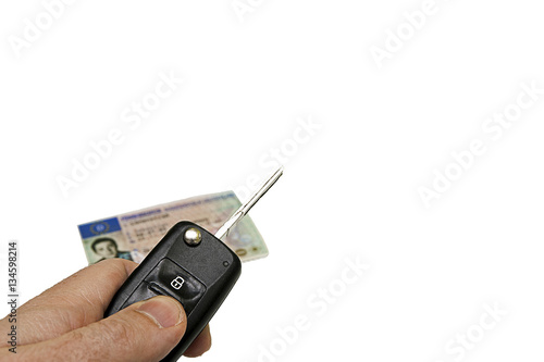Autoschlüssel und Führerschein in einer Hand auf weißen Hintergrund photo