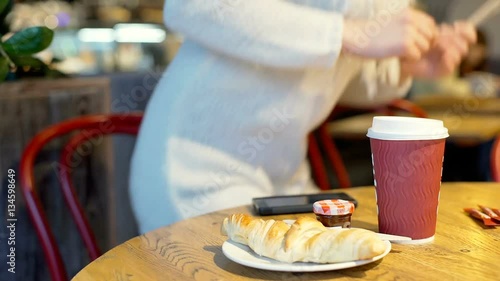 Girl brings herself wooden cutlery while having a breakfast in the bistro, steadycam shot
