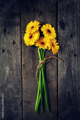 Fototapeta Naklejka Na Ścianę i Meble -  Beautiful Fresh Spring Yellow Gerbers on Old Vintage Wooden Tabl