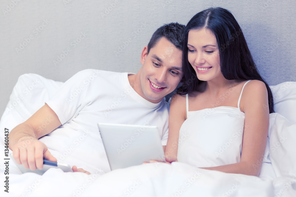 smiling couple in bed with tablet pc computers smiling couple in bed with tablet pc computers