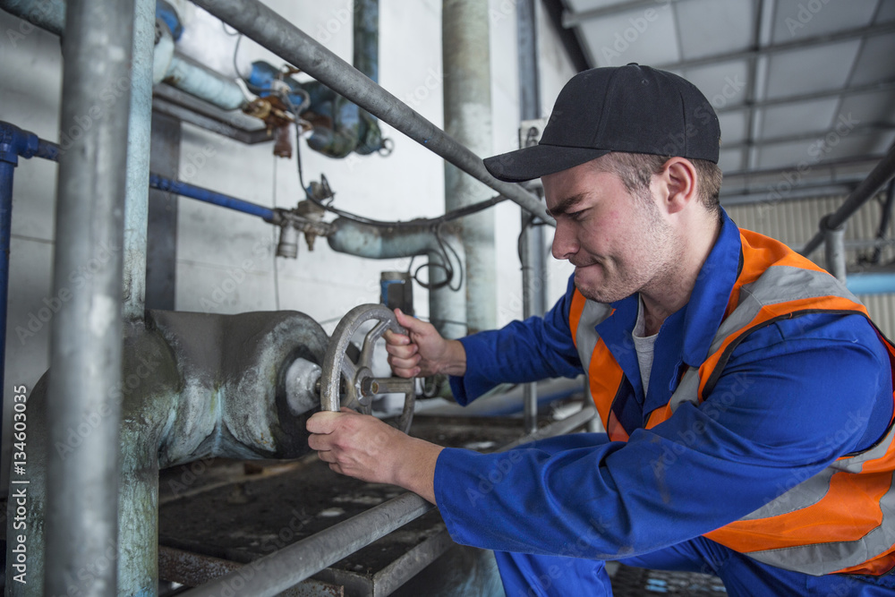 Worker turning valve in factory Worker turning valve in factory