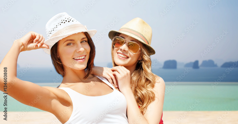 happy young women in hats on summer beach happy young women in hats on summer beach