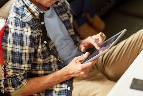 close up of man with tablet pc sitting at cafe