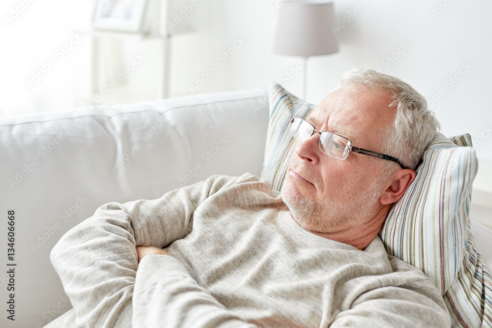 close up of senior man in glasses thinking at home close up of senior man in glasses thinking at home