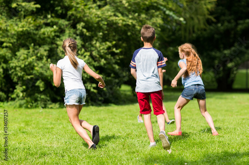 group of happy kids or friends playing outdoors