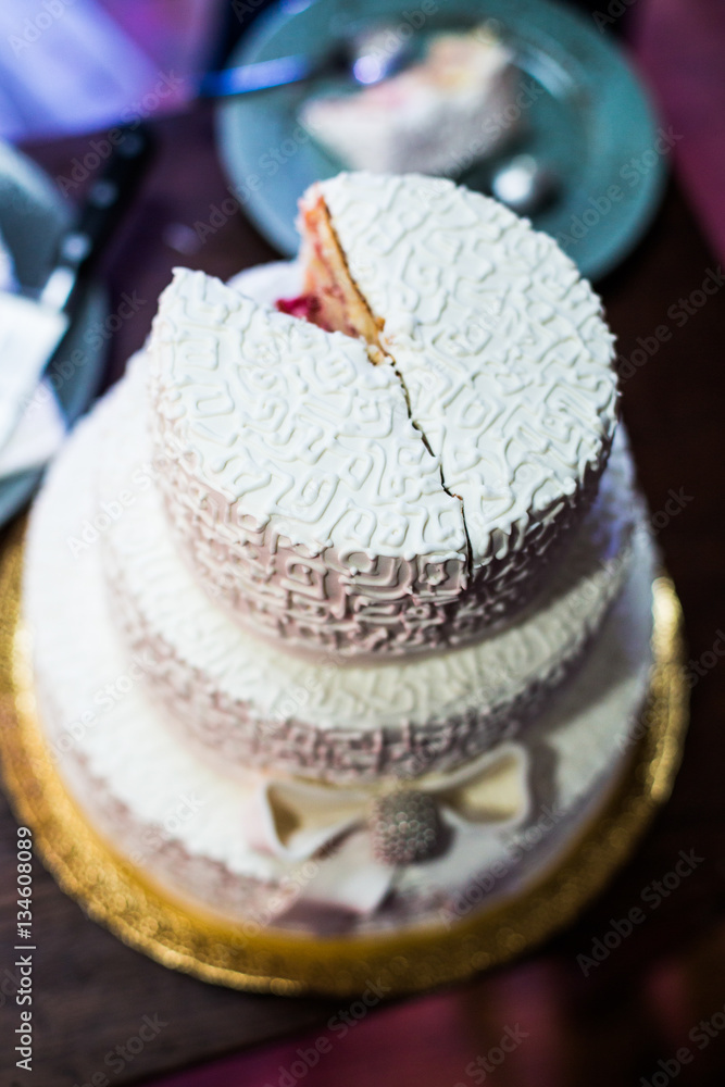 White wedding cake decorated with crystals and glaze bow stands White wedding cake decorated with crystals and glaze bow stands